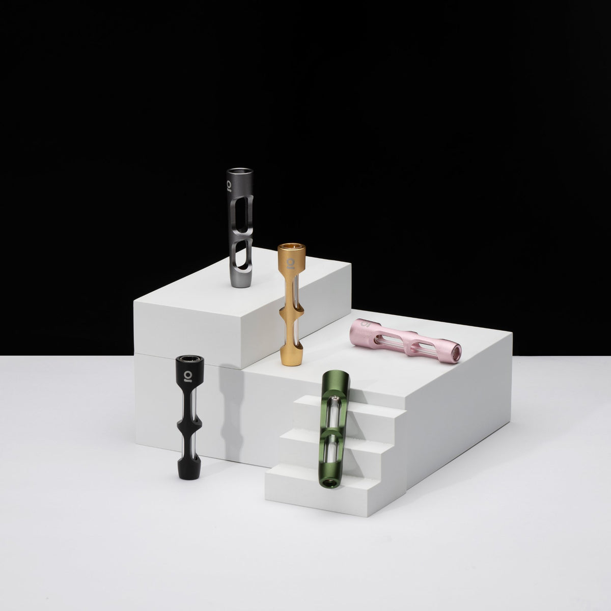 ONGROK aluminum chillum pipes with glass inner tubes in gunmetal, gold, pink, green and black on white risers